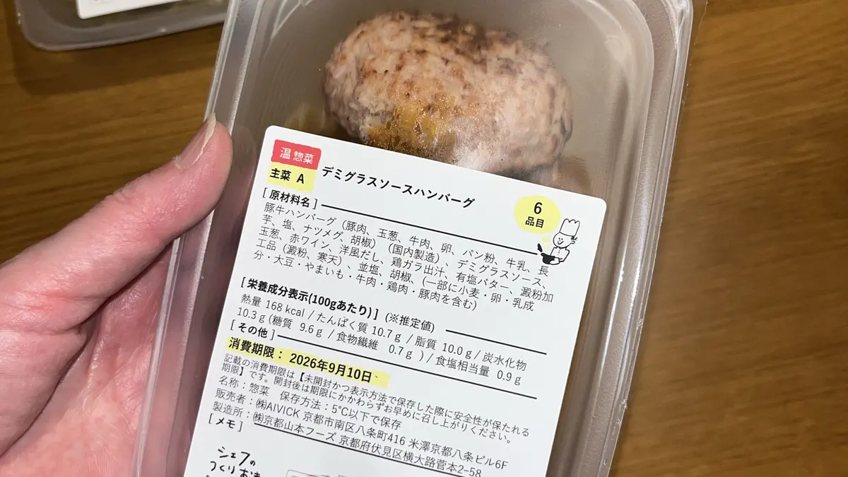 手に持ったデミグラスソースハンバーグの容器